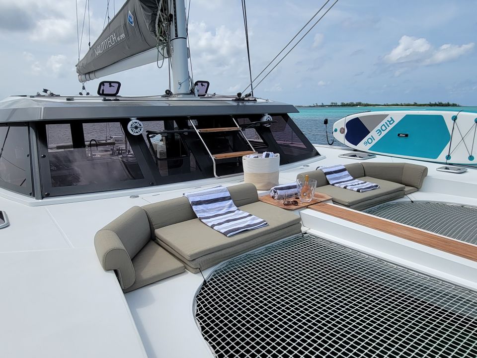 Forward trampoline and cockpit of a sailing catamaran with a paddleboard on deck