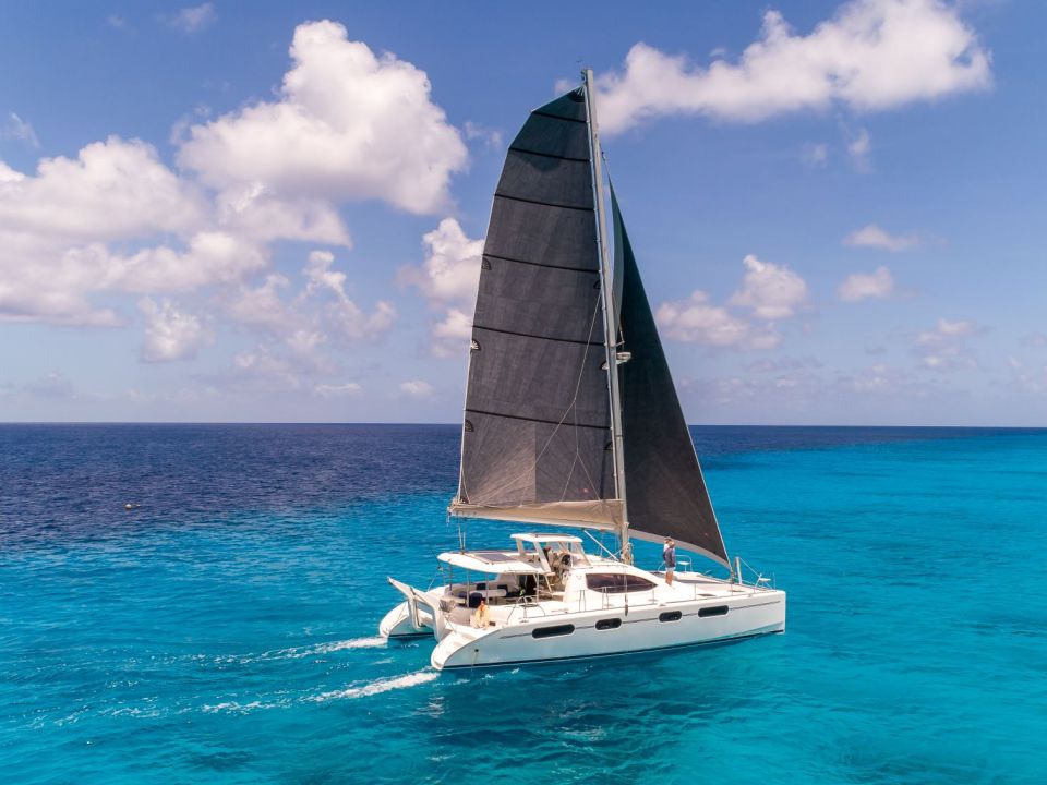 Sailing catamaran under sail on turquoise water