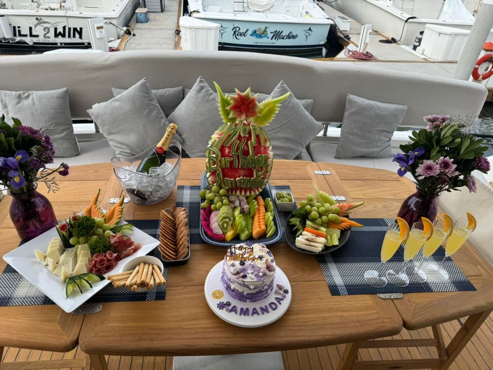 Fruit, flowers and snacks arranged on an aft-deck table aboard a yacht