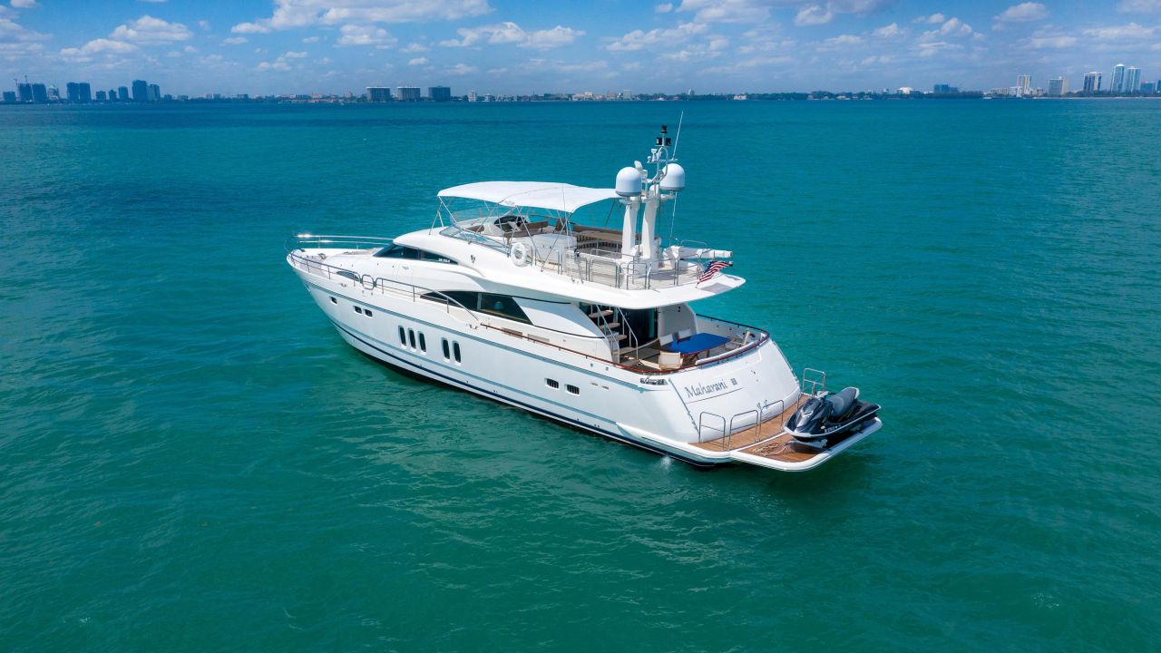 Large white motor yacht cruising on calm teal water