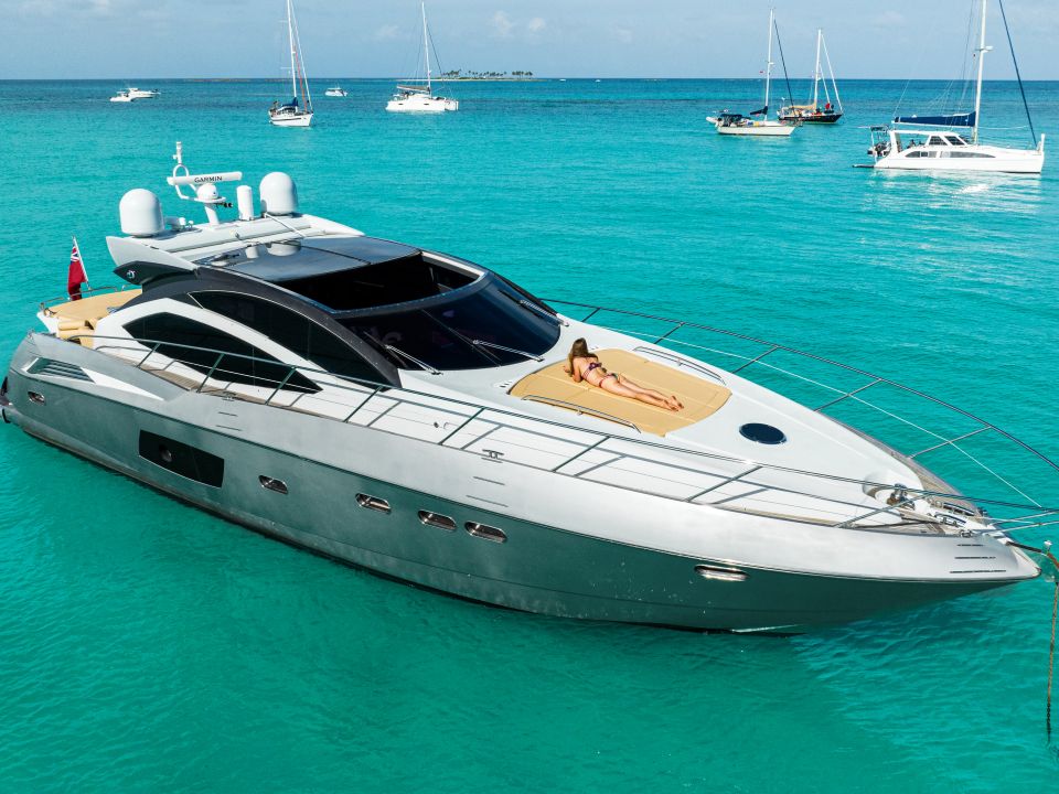 Sport yacht anchored in turquoise water with sailboats nearby